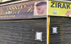 A grid image showing the closure order notices outside Zirak Mini Market and Guarantee Barber shops