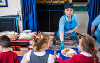 Dinner lady serving meals to primary school children