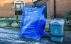 Image of household waste containers on a curbside including blue bag and food caddy